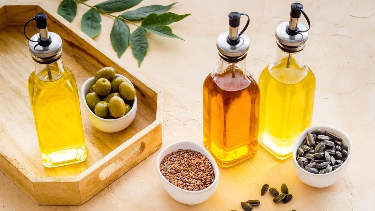 Ποικιλία από διαφορετικά μαγειρικά λάδια σε μπουκάλια με μείγμα μπαχαρικών και ελιών