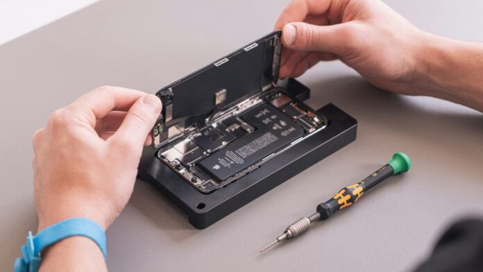 A person opens an iPhone so that it can be repaired.
