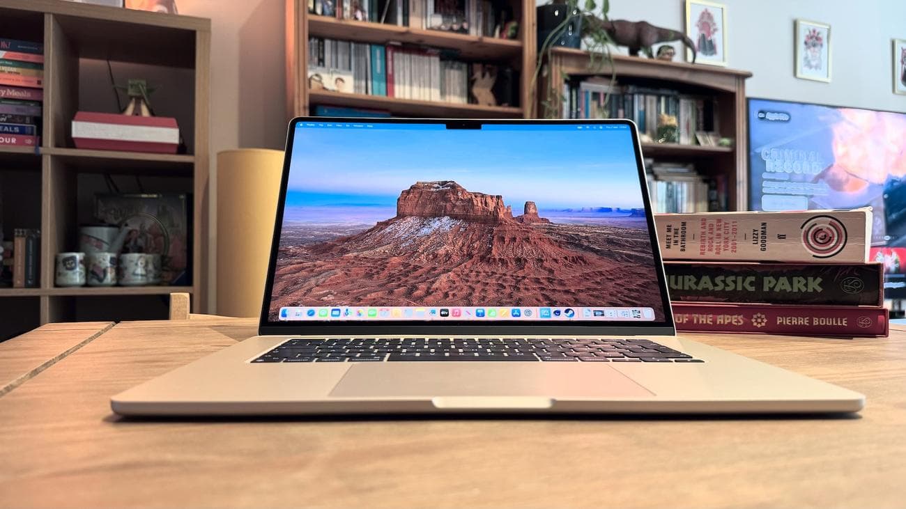 Το 2024 MacBook Air M3 σε ένα ξύλινο τραπέζι μπροστά από ένα ράφι.
