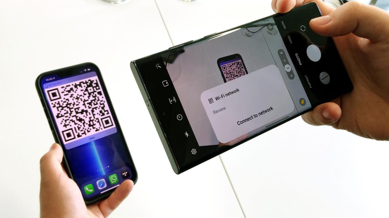Ένα Samsung Galaxy S22 Ultra που σαρώνει έναν κωδικό QR Wi-Fi από ένα iPhone 13 Pro Max