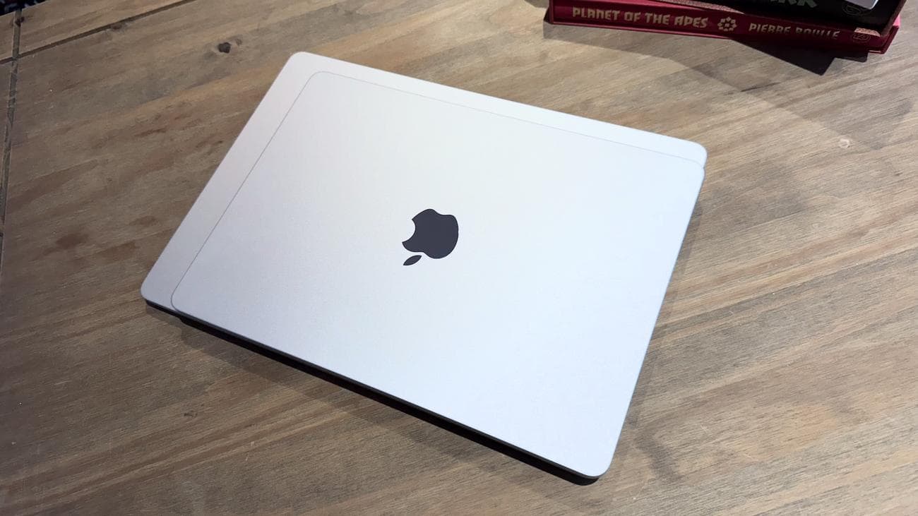 Το 2024 MacBook Air M3 σε ένα ξύλινο τραπέζι μπροστά από ένα ράφι.