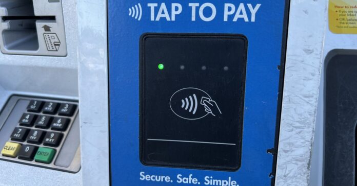 Credit card reader with a message stating Tap to Pay and logos for various payment cards on a gas pump in Lafayette, California, May 9th, 2024.
